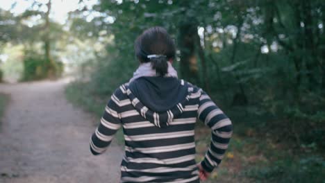 young girl running on a path in a forest