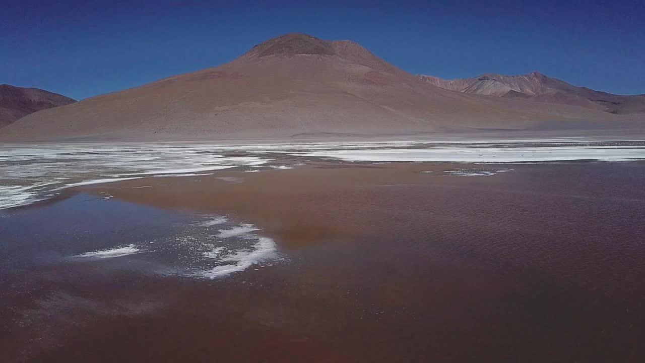 Hovering above Bolivia's expansive salt flats, the aerial perspective captures a mesmerizing scene