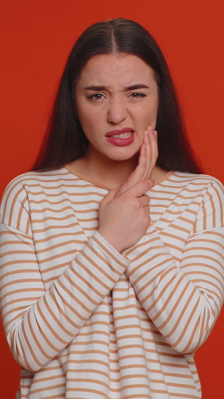 Woman touching cheek suffering from toothache cavities or gingivitis waiting for dentist appointment