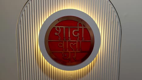 stock footage of elegant wedding entrance decoration featuring hindi text "shaadi wala ghar" illuminated with warm golden lighting.