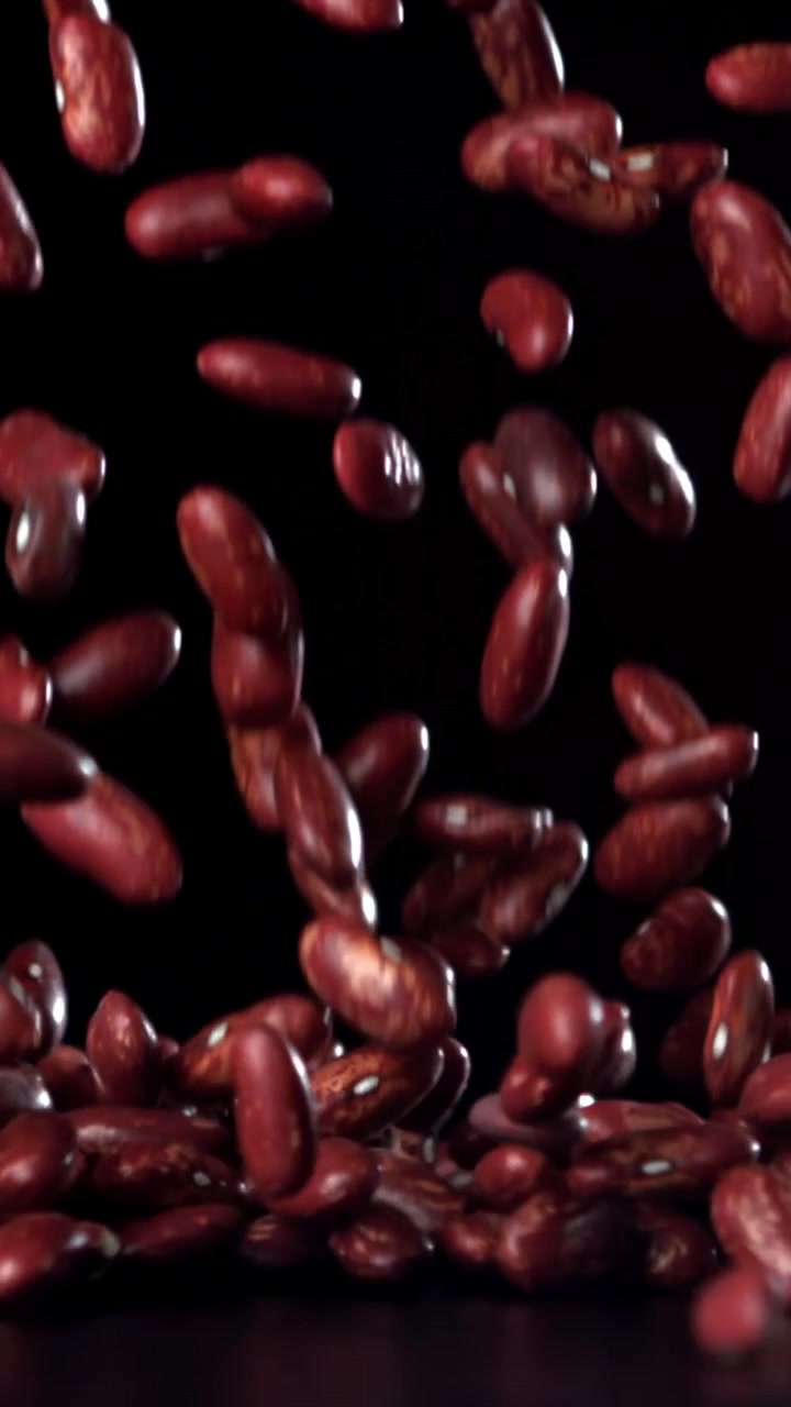 Red Kidney Beans Falling in Slow Motion on Black Background