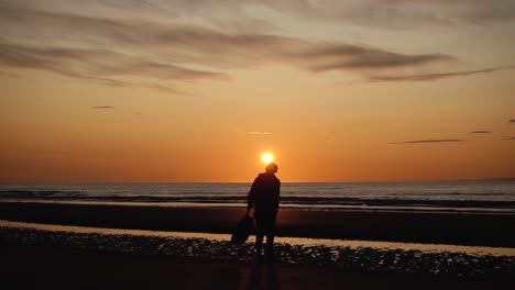 hombre corriendo con guitarra en la playa de arena trasera al atardecer-19