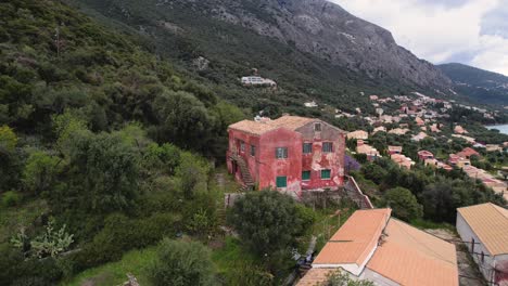 Toma-Giratoria-En-Sentido-Contrario-A-Las-Agujas-Del-Reloj-De-Una-Casa-Roja-Y-Antigua-En-Las-Montañas-Cubiertas-De-Bosque-De-Corfú