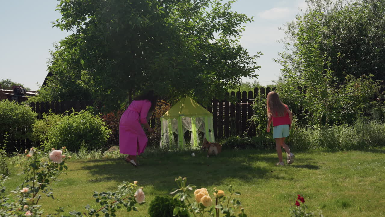 Mom And Young Girl Enjoy Vibrant Garden Activities, Mother And Child Playing Amidst Colorful Flowers Outside Together, Mother And Her Young Daughter Delight In Lively And Colorful Outdoor Garden Play
