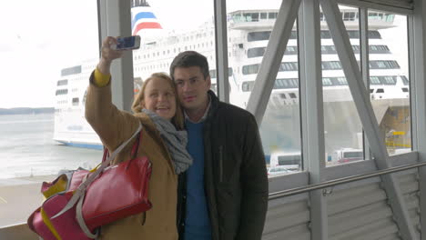 happy couple making selfie with phone in harbor