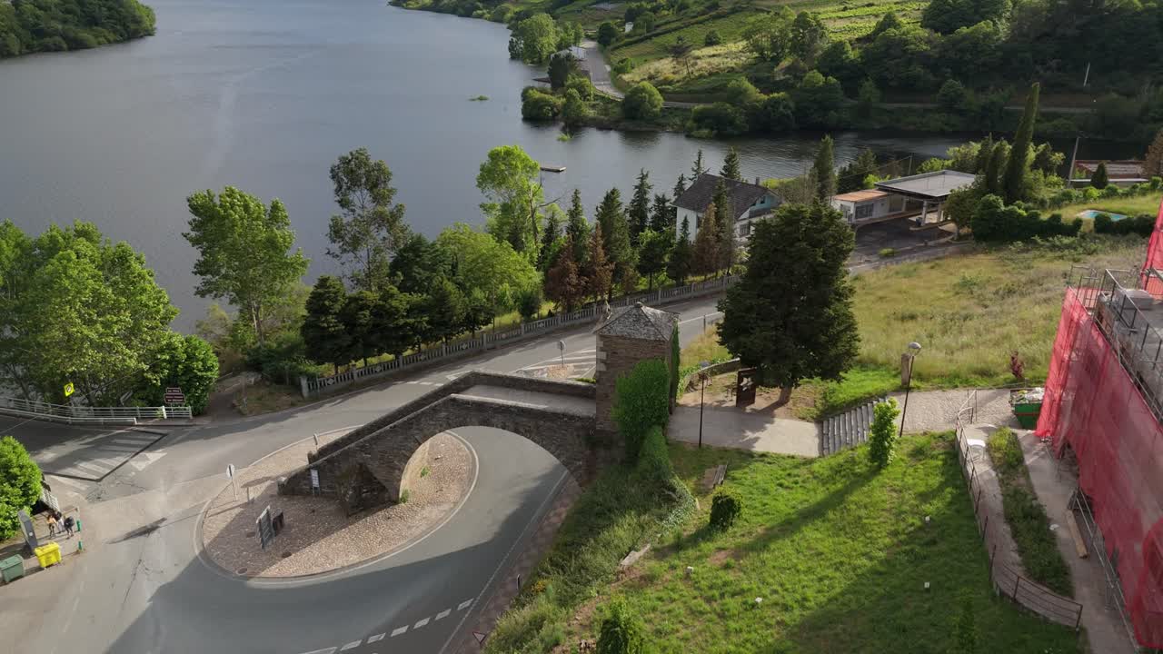 Aerial orbit shot of the Chapel of Our Lady of the Snows at the entrance of Portomarín, Galicia. Key landmark on the Camino de Santiago with historic and spiritual significance.