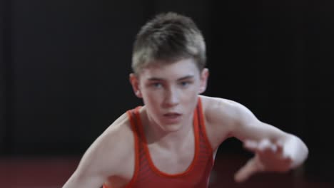 teenage wrestler wearing a red singlet and practice his shadow wrestling drills