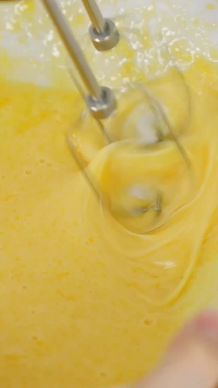Vertical clip showing egg yolk mixed with powdered sugar for tiramisu recipe step