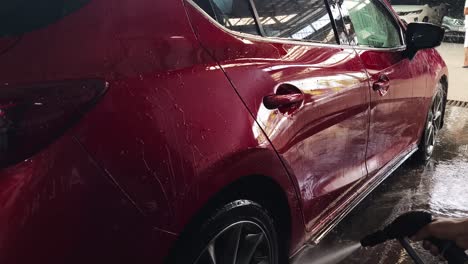 red car being washed at a car wash