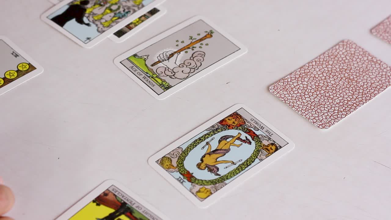Hand flipping tarot cards of Celtic cross spread, panning shot