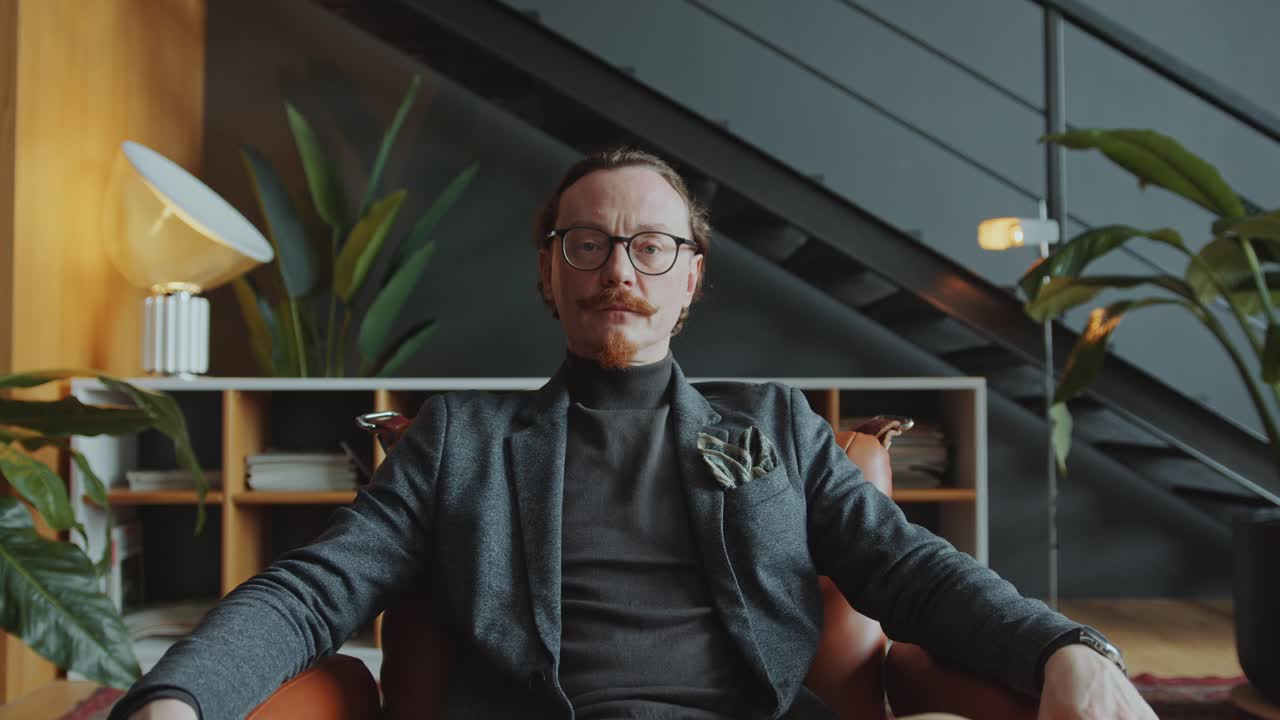 Portrait of Confident Businessman Sitting in Armchair in Modern Office