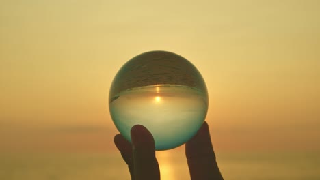 magic sunset view in a crystal ball on your hand.