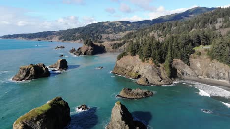 drone flies over sea stacks in turquoise water