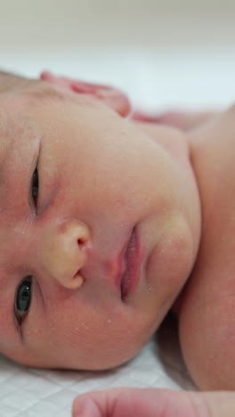 infant hiccups. newborn baby boy laying on hospital table. side portrait of a cute child. concept of hospital and happy motherhood.. vertical video