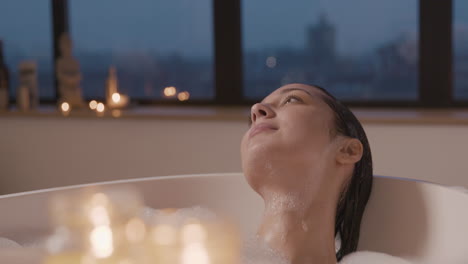 Close-Up-View-Of-Candles,-In-The-Background-A-Woman-Taking-A-Bath-In-A-Bathtub