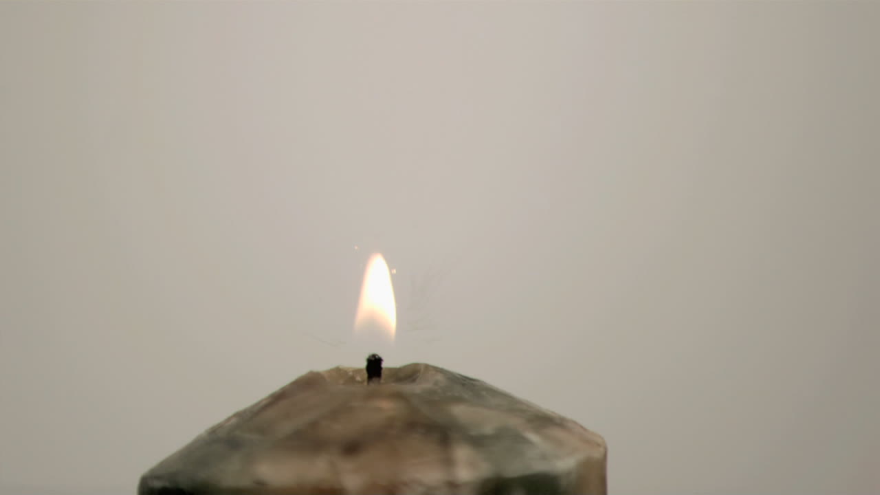 Goccia che cade al rallentatore su una candela