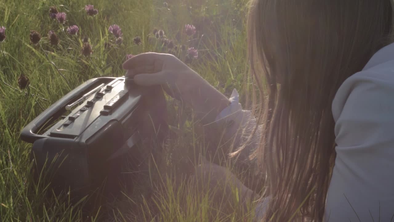 fm am 휴대용 라디오에서 다이얼을 조정하는 여성