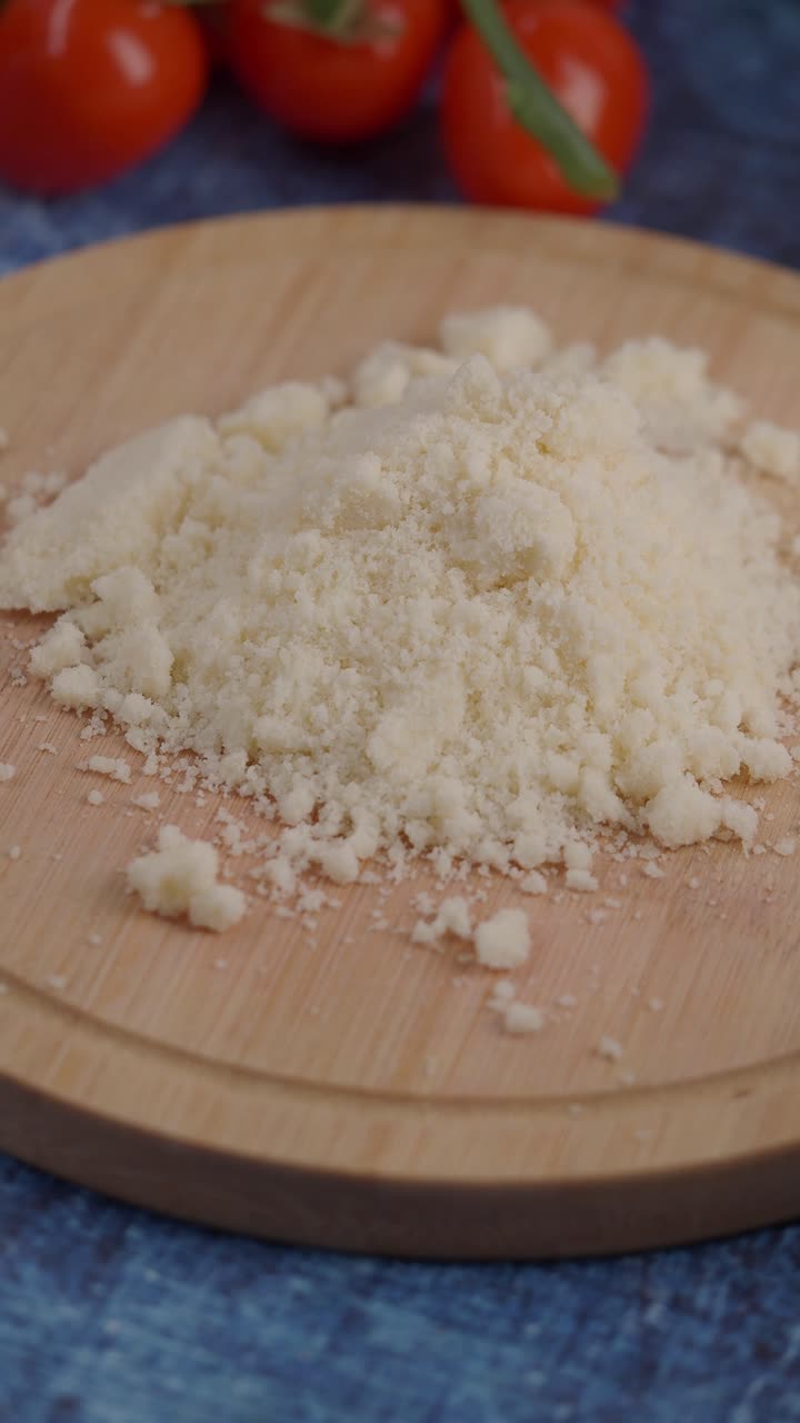 Primo piano di Parmigiano grattugiato su un tagliere di legno