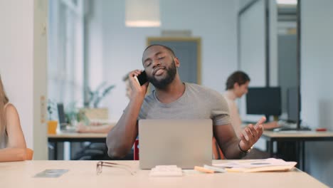happy business man talking phone at coworking space. young guy having phone