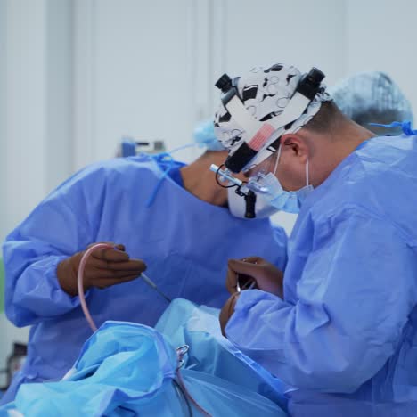 surgical process with the help of new medical equipment. contemporary equipment in the operating room. specialists in blue uniform perform an operation