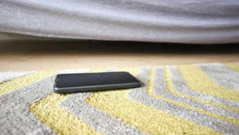 smartphone on a carpet under a bed