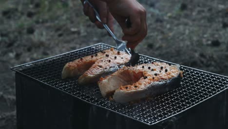Grilled-salmon-bbq-taking-with-fork-from-grill.-Roasted-salmon-steak-on-grill