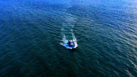 amazing rotating aerial of boat splitting through the open ocean waters
