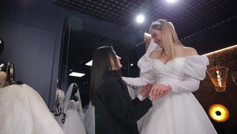 bride fitting wedding dress with help of consultant