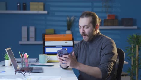 the man who happily uses the phone dances and has fun.