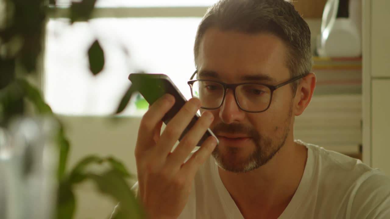 hombre hablando por teléfono móvil en casa 4k