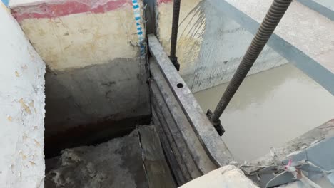 rueda de la puerta de inundación del vertedero con panela hacia abajo para revelar el agua que pasa a través