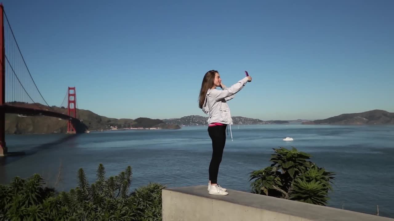 mujer tomando una selfie con el puente golden gate