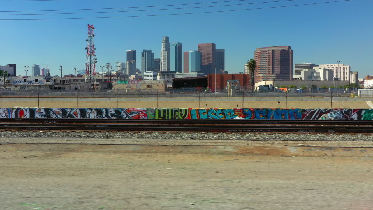 Flying right with a drone infront of abandoned train tracks with the Los Angeles Skyline in the Background, California USA