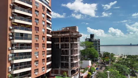 perspectiva de dron capturando un sitio de construcción y un edificio terminado uno al lado del otro, mostrando la mezcla armoniosa de progreso y logro