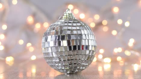 ornamento de bola de discoteca de navidad brillante y luces parpadeantes detrás
