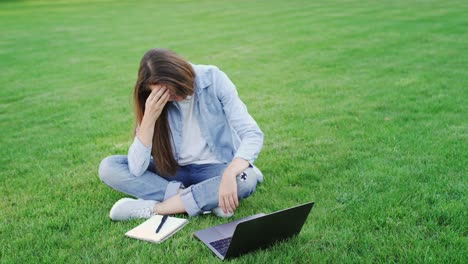 Thoughtful-woman-study-online-on-laptop-computer-in-summer-park