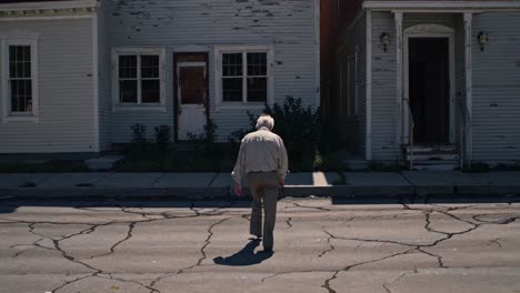 old man walking down a desolate street