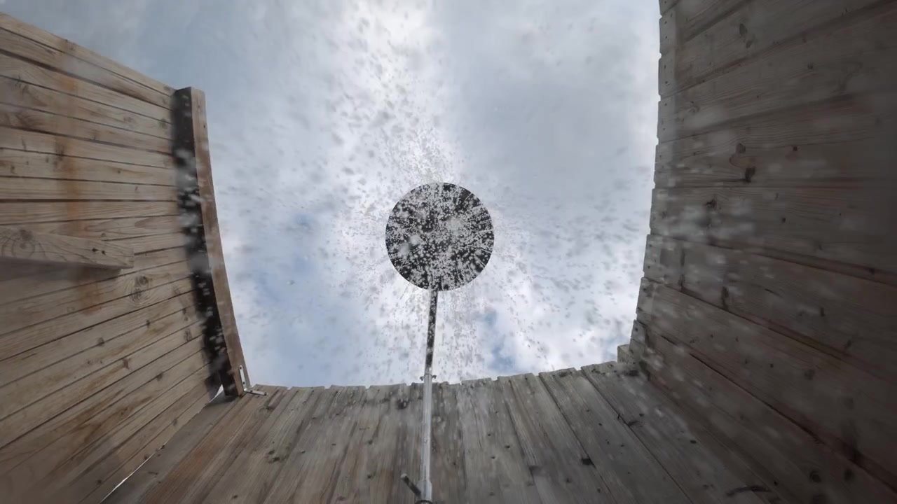 Outdoor shower head enclosed by rustic wooden walls, offering a refreshing experience under a cloudy summer sky