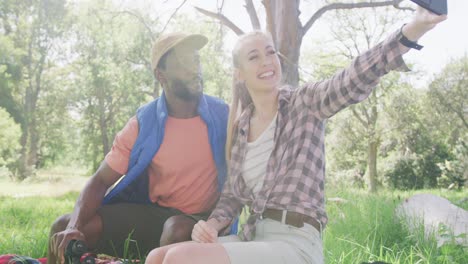 Fröhliches,-Vielfältiges-Paar-Beim-Camping-Und-Selfie-Mit-Dem-Smartphone-Im-Park,-Zeitlupe