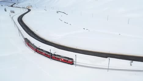 aerial drone shots featuring a vibrant red train gliding through a snow-covered wonderland