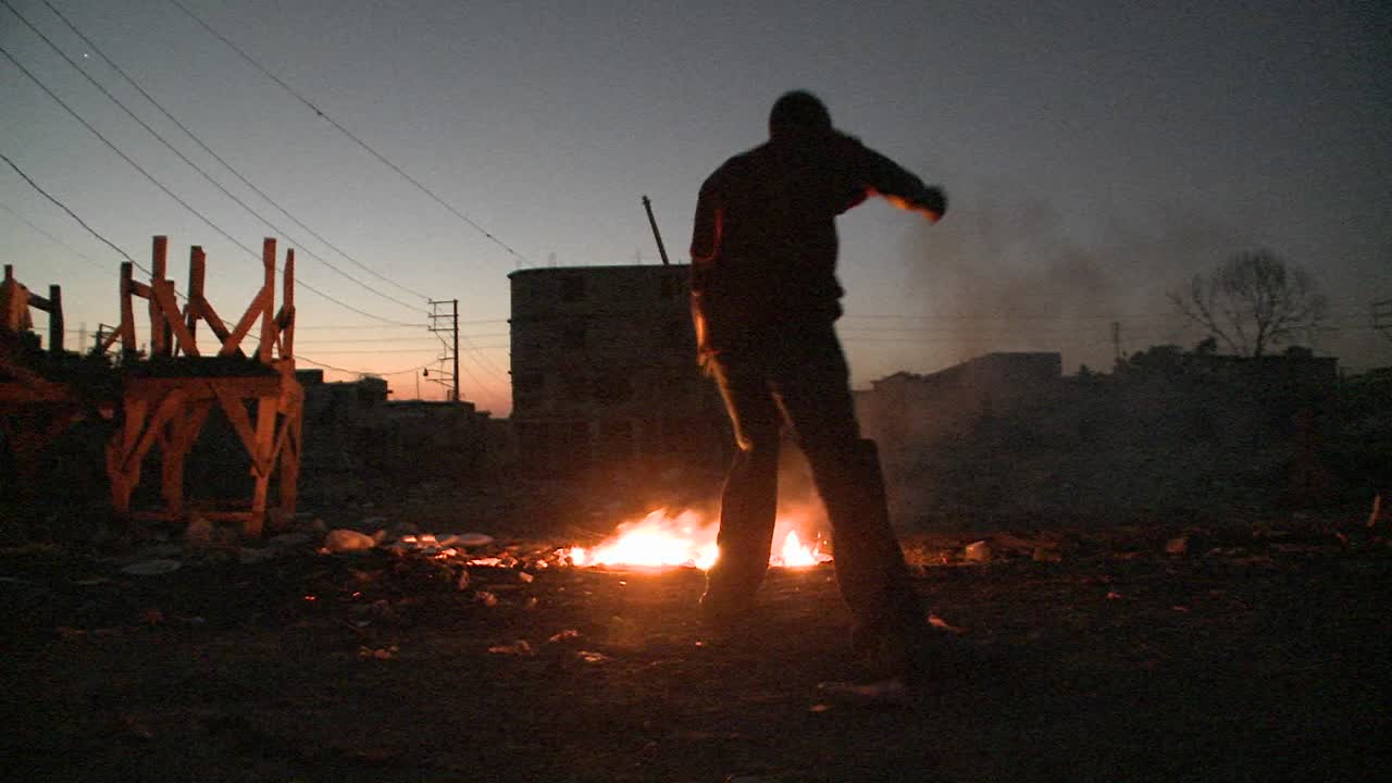 un hombre baila en silueta frente a un fuego