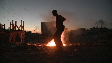 un hombre baila en silueta frente a un fuego