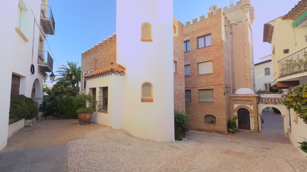 Scenic entrance to the charming Roc de Sant Gaietà village on Spain’s Costa Dorada, featuring Mediterranean and Moorish-inspired architecture with brick towers, archways and narrow alleys