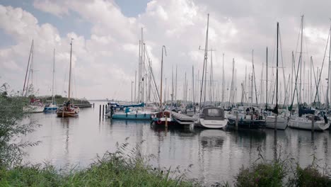 In-a-dutch-sail-harbour,-a-ship-departs-to-sail-the-big-lake