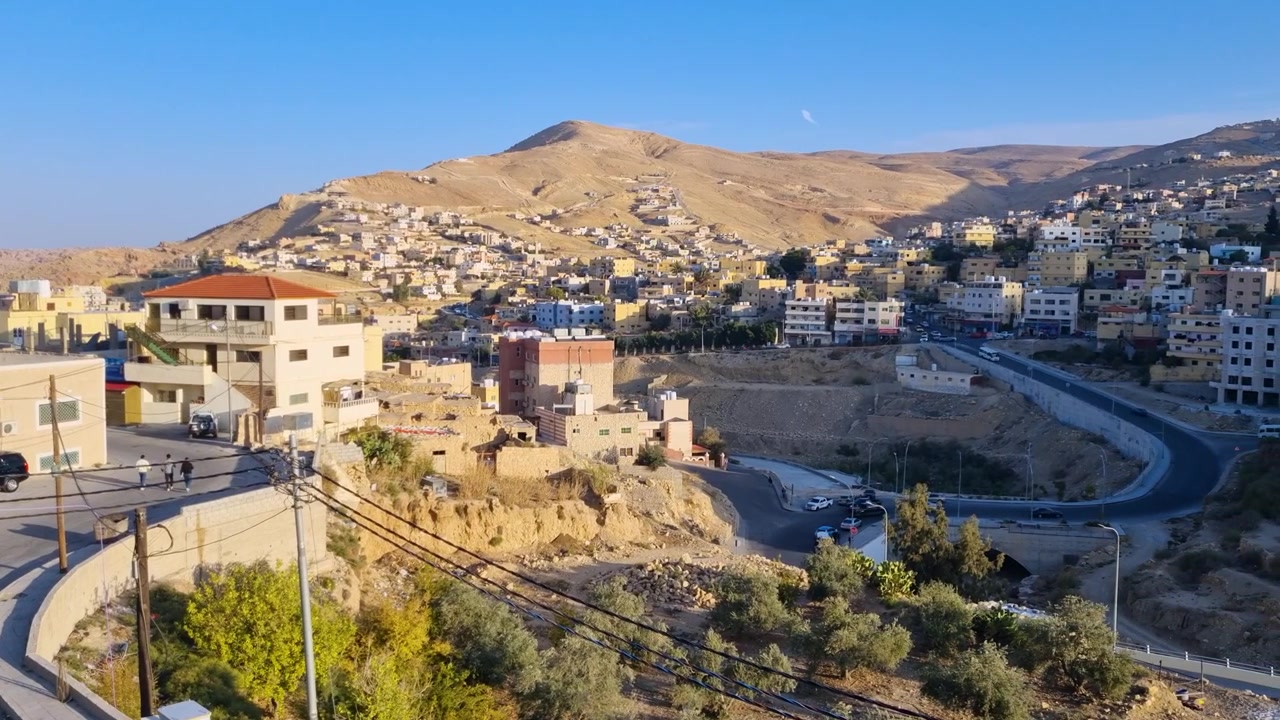 Panorama all'alba su Wadi Musa, Giordania, che cattura la tranquilla città desertica adagiata tra dolci colline nella soffice luce del mattino. Un paesaggio urbano sereno che mostra la bellezza pacifica di questa città turistica.