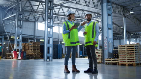 factory workers discussing shipment distribution checking tablet information