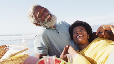 Glückliches-Afroamerikanisches-Paar-Beim-Picknick-Am-Sonnigen-Strand