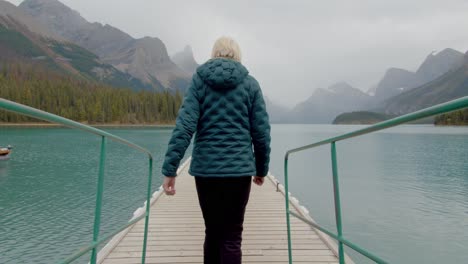 Frau-Im-Freien,-Die-Einen-Pier-An-Einem-Atemberaubenden-See-In-Den-Kanadischen-Rocky-Mountains-Hinuntergeht