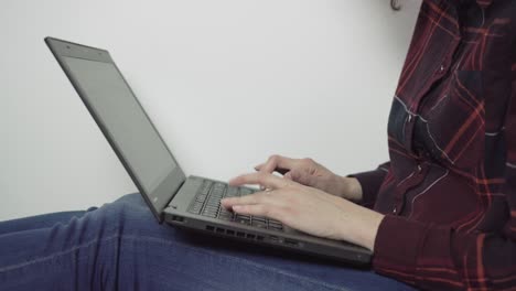 Side-shot-of-girl-typing-on-black-laptop---side-view,-closeup