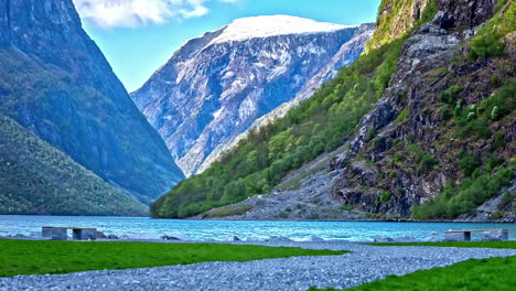 Time-lapse-of-clouds-casting-shadows-over-mountains-as-ship-travels-in-water